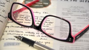 ペンとメガネとノートの画像